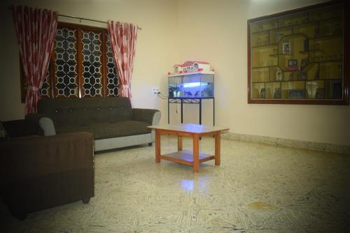 a living room with a couch and a coffee table at Reunion Villa in Udupi