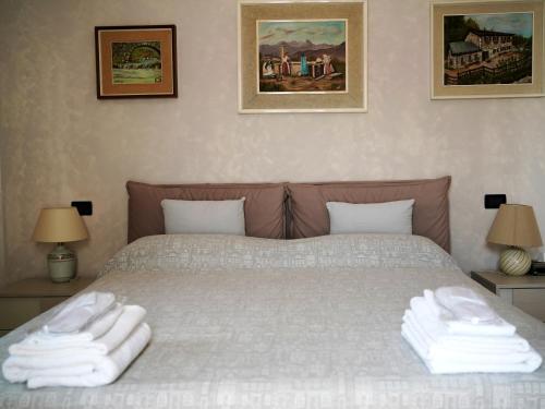 a bedroom with a bed with white towels on it at Le Cicogne in Rovereto