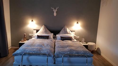 ein Schlafzimmer mit einem Bett mit blauer Bettdecke und Kissen in der Unterkunft Landidylle in Bremke
