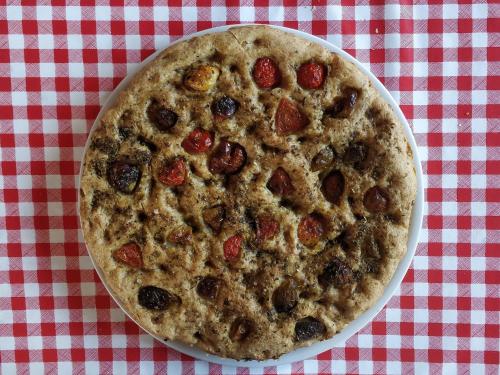 a pizza sitting on top of a red and white checkered table at La Luna nel Parco in Fano