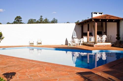 a swimming pool with chairs and a house at Senior Parque Hotel in Santa Rosa