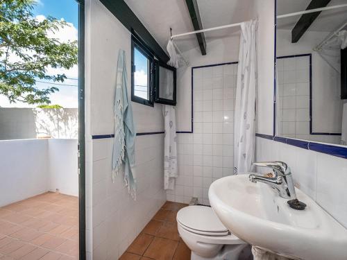 a bathroom with a sink and a toilet and a window at VILLA EN CAP EN FONT in Cap d'en Font