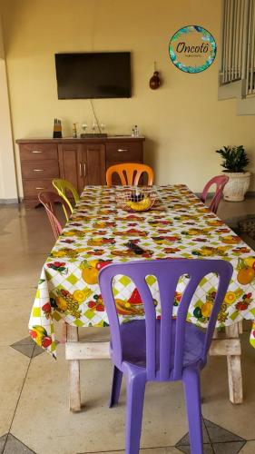 a dining room table with a colorful tablecloth and chairs at Oncotô Palmas Hostel in Palmas