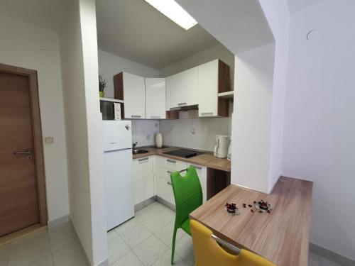 克爾克的住宿－Apartmani Alta，厨房配有木桌和绿色椅子