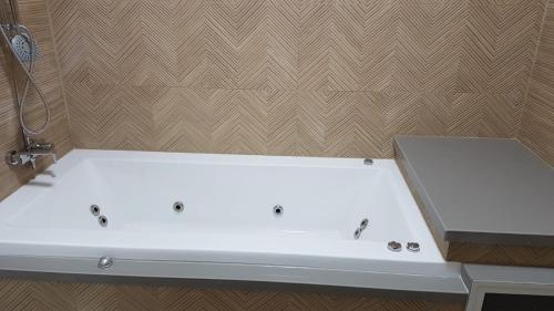 a white bath tub sitting in a bathroom at Suit November in Majdal Shams