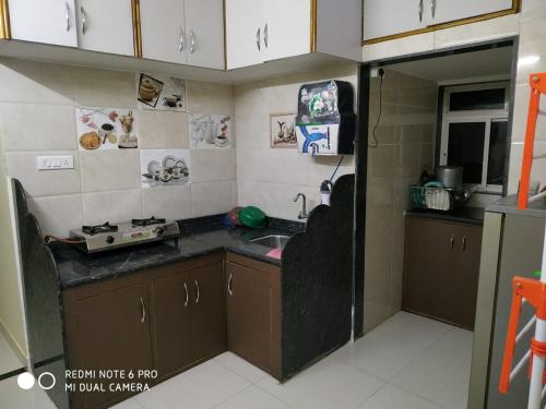a small kitchen with a sink and a microwave at Mayuri cottage in Mahabaleshwar