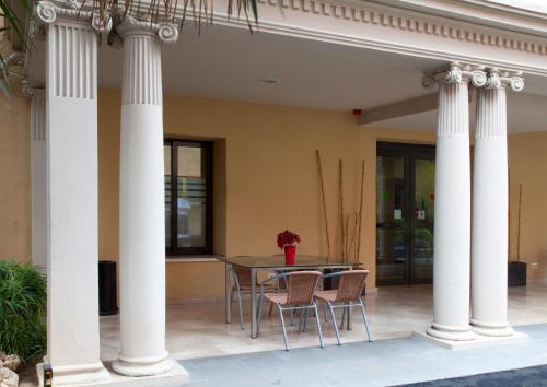 a patio with a table and chairs with columns at Residència Erasmus Gracia in Barcelona