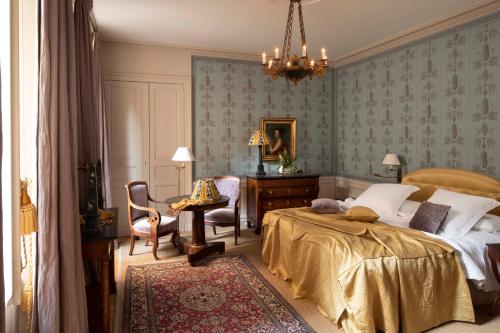 a bedroom with a bed and a desk and a chair at La Mirande in Avignon