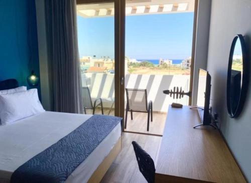 a bedroom with a bed and a view of a balcony at Meropi Hotel & Apartments in Malia