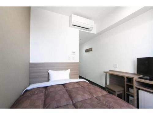 a bedroom with a bed and a desk and a television at R&B Hotel Shin Osaka Kitaguchi - Vacation STAY 15196v in Osaka