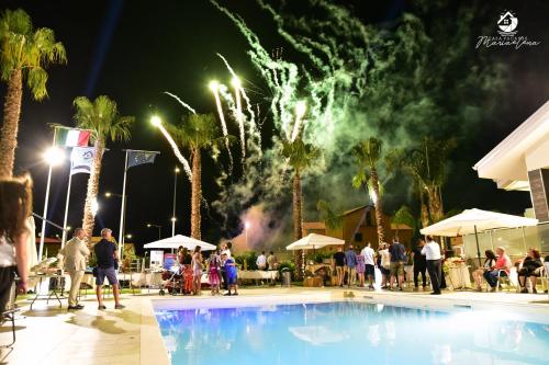 a group of people standing around a pool with fireworks at CASA VACANZE MARIAELENA - MOMENA in Rossano Stazione