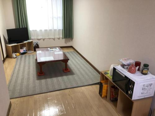 Grand Heights - Vacation STAY 17555v في Amakusa: غرفة معيشة مع طاولة قهوة وتلفزيون