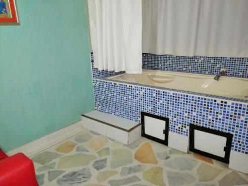 a bathroom with a tub with a blue tiled floor at HOTEL YORYTANIA BOUTIQUE in Pitalito