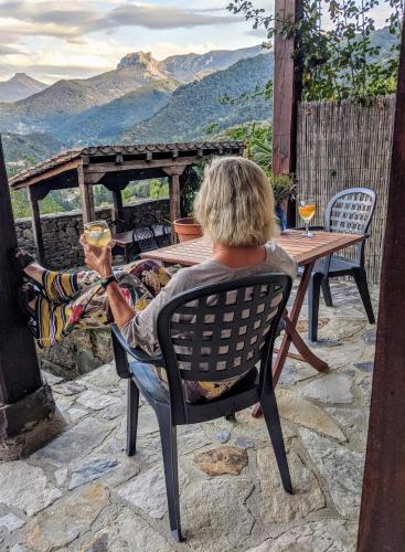 a man sitting in a chair at a table at Olmares Terrace Apartment - Picos de Europa in Lomeña