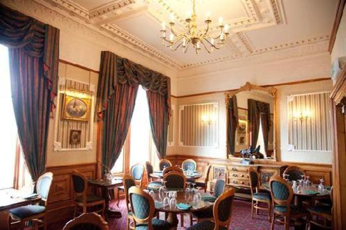 a living room filled with tables and chairs at The Grand Hotel in Lerwick