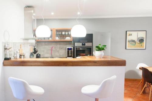a kitchen with two white chairs and a counter at Holiday home Gabriela in Korčula