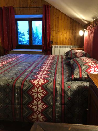 1 dormitorio con 2 camas y ventana. en Rifugio Baita Gimont, en Cesana Torinese