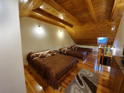 sypialnia z 2 łóżkami w pokoju z drewnianym sufitem w obiekcie Apartament Na Skarpie Czarna Wieś w Rajgrodzie