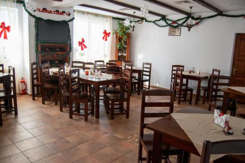 a dining room with tables and chairs and christmas decorations at Vila Alisa in Bran