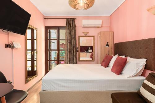 a bedroom with pink walls and a large white bed at Manina Superior Apartment in Thessaloniki