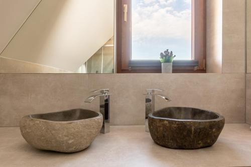 a bathroom with two large stone sinks and a window at Tatra Apartments z zewnętrznym jacuzzi in Biały Dunajec