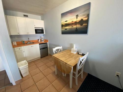 a small kitchen with a wooden table and chairs at Coral Sands Inn in Ormond Beach