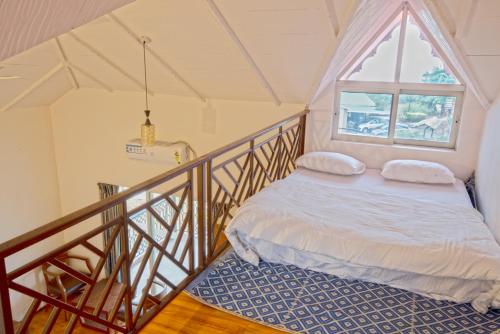 a bedroom with a bed and a window at Kabila Agro Tourism in Mahabaleshwar