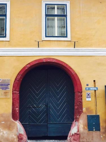 a building with a black garage door and two windows at World Studio 5 in Sibiu