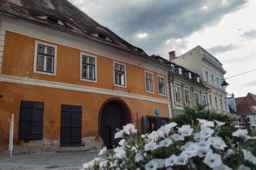 an orange building with a bunch of windows on a street at World Studio 5 in Sibiu