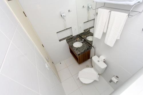 a white bathroom with a toilet and a sink at Lacqua diRoma com acesso Acqua Park e Splash in Caldas Novas