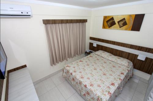 a small bedroom with a bed and a window at Lacqua diRoma com acesso Acqua Park e Splash in Caldas Novas