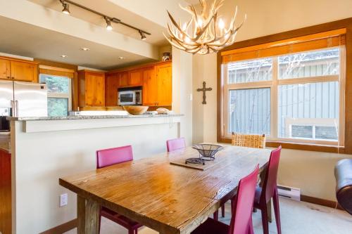 a kitchen with a wooden table and pink chairs at Ski in Ski out Minutes from Village, Private Hot Tub Sleeps 6 Free Shuttle in Whistler