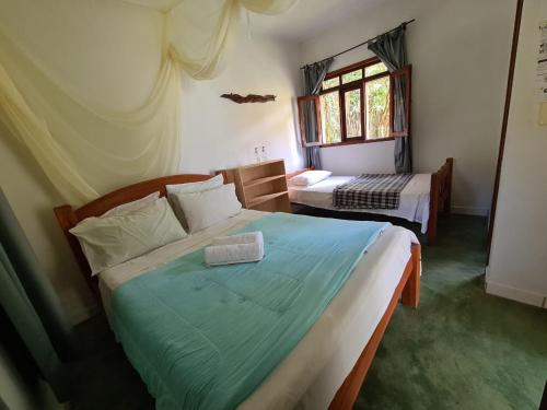 1 dormitorio con 2 camas y ventana en Casa da Trilha, en Vale do Capao