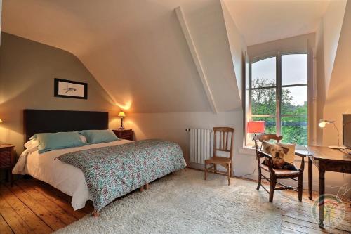 a bedroom with a bed and a desk and a window at La Maison Les Mimosas in Le Minihic-sur-Rance