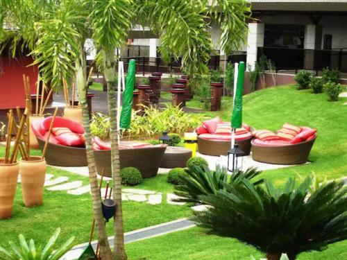 a garden with a bunch of chairs and palm trees at Flat Life Resort com vista do Lago in Brasilia