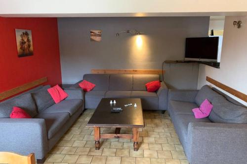 a living room with couches and a coffee table at Spacious old farmhouse with top-of-the valley view in Trois-Ponts