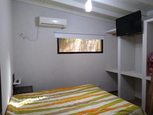 Habitación pequeña con cama y ventana en PROSPERIDAD AZAHAR, en Mar de las Pampas