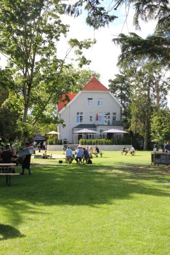 Un groupe de personnes assises dans l'herbe dans un parc dans l'établissement Villa Glanzstoff, à Heinsberg