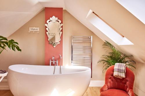 a bathroom with a large white tub in a attic at The Old Forge in Ashbourne