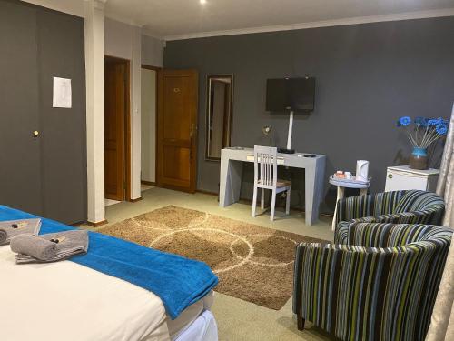 a bedroom with a bed and a table and a chair at Marion Lodge in Johannesburg