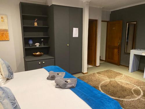 a bedroom with a bed with shoes on it at Marion Lodge in Johannesburg