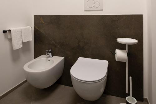 a bathroom with a white toilet and a sink at Le Cupole Suites & Apartments in Trapani