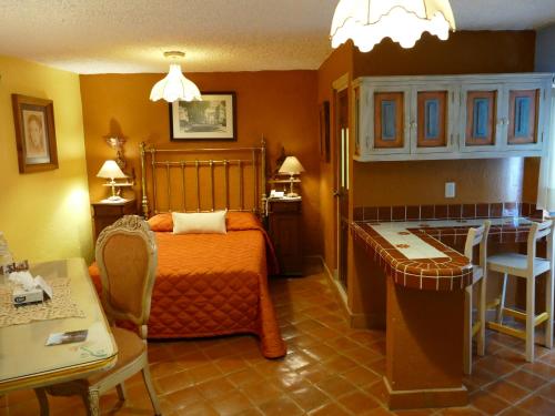 a bedroom with a bed and a table and a kitchen at El Meson de los Poetas in Guanajuato
