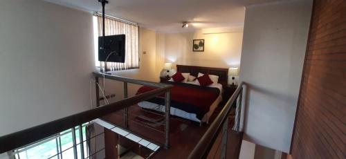 a room with a balcony with a couch and a television at America Departamentos in Santiago