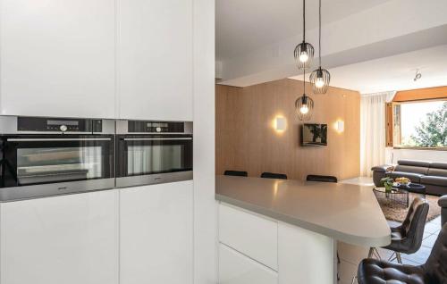 uma cozinha com armários brancos e um balcão branco em Apartman Villa Pećine em Rijeka
