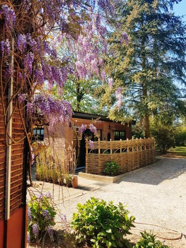 a house with a fence and purple flowers at Vakantiehuis ABEL in Dilsen-Stokkem