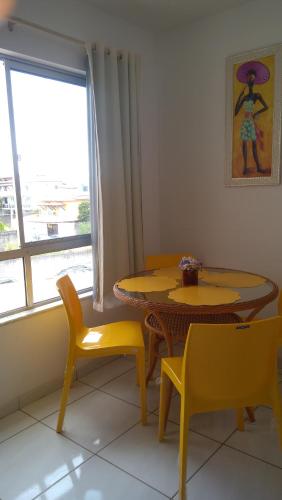a dining room with a table and chairs and a window at AP Praia - Vog 2 quartos com AR e D'Ouro Park-Rua dos Tangarás, 20 todo climatizado in Ilhéus