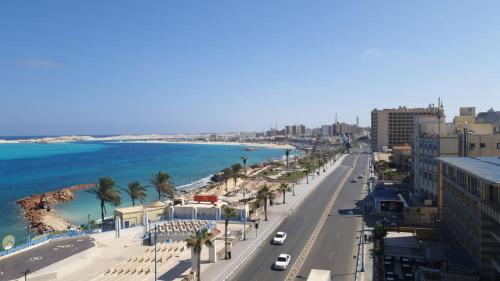 a view of a city with palm trees and the ocean at شاليهات بورتو مطروح فيو بحر Porto Matrouh Sea View Families Only in Marsa Matruh