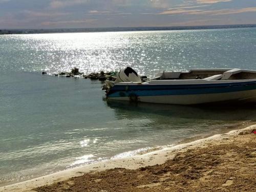 a blue and white boat sitting on the beach at شاليهات بورتو مطروح فيو بحر Porto Matrouh Sea View Families Only in Marsa Matruh