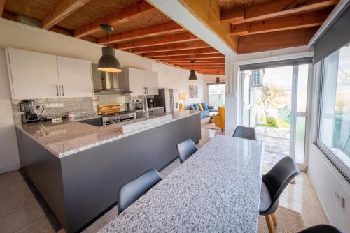 a kitchen with a counter and a table and chairs at LIMASSOL AKROTIRI VINE COTTAGE a in Limassol